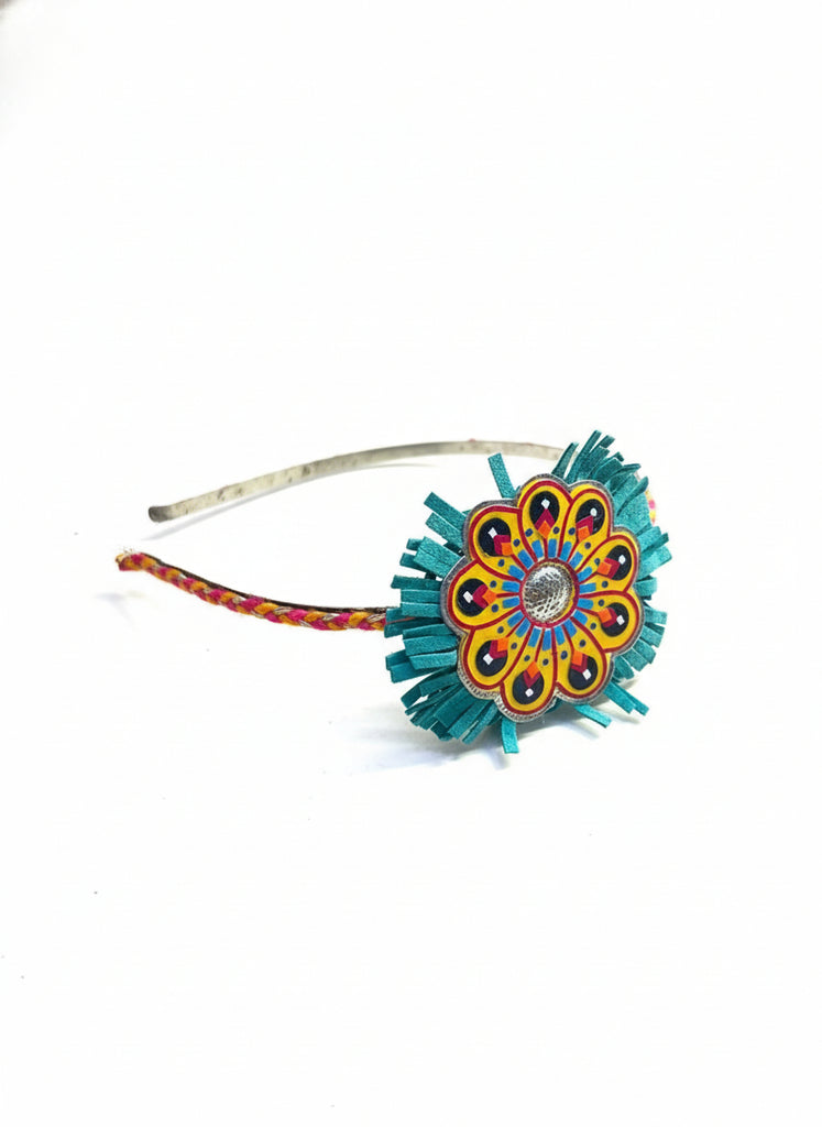 Colorful flower-shaped hairband on a wooden surface with a dark blue background