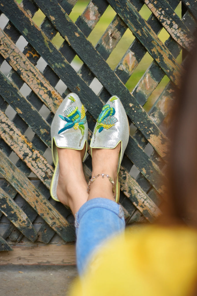 Neon thread colored embroidered motif on pointed glittery mule 